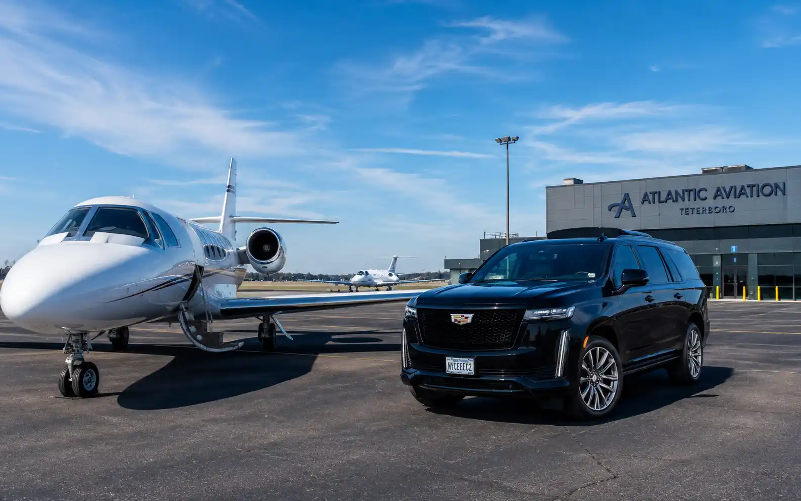 Luxury car waiting beside a private jet at a Teterboro FBO terminal