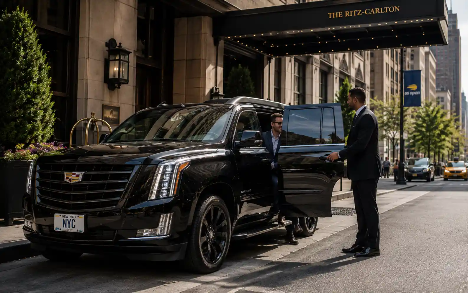 Chauffeur holding open the door of a luxury car outside a Manhattan hotel