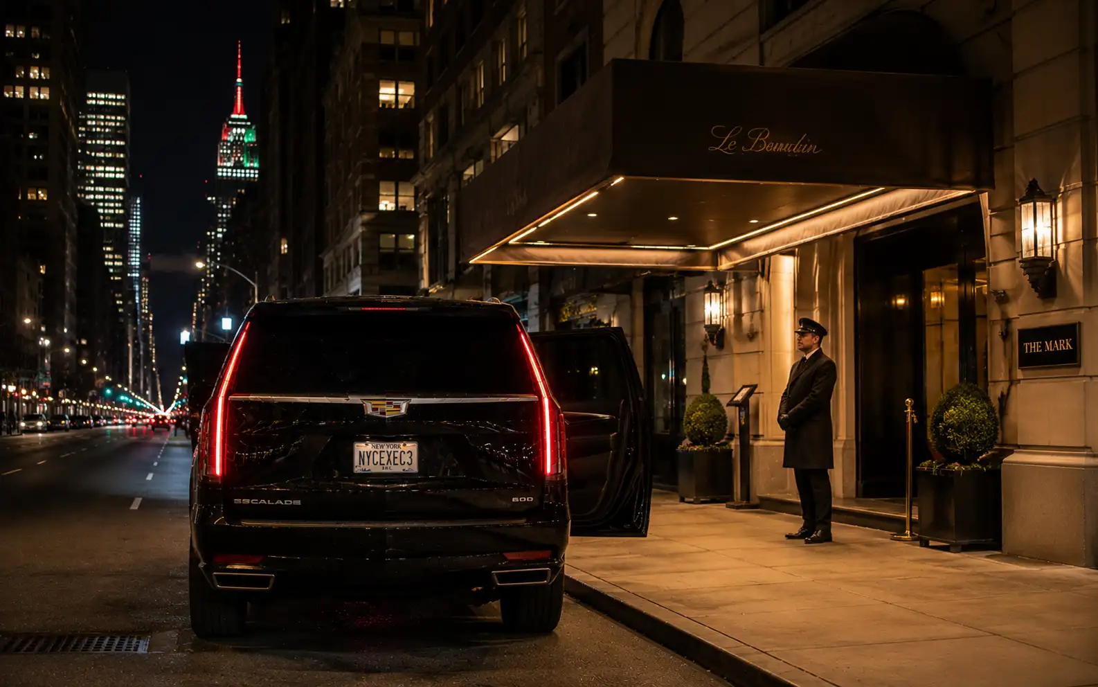 Chauffeur waiting beside a black car outside a venue late at night in New York
